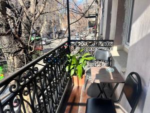 balkon z drewnianym stołem i 2 krzesłami w obiekcie Apartment Dadiani 26 w mieście Tbilisi City