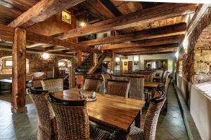 a dining room with a wooden table and chairs at Barokni Spejchar in Tlučná