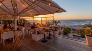 a restaurant with a view of the beach at sunset at Studio dans résidence de standing avec parking et sa terrasse vue mer in Bidart