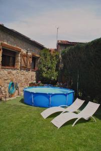 2 sillas y una piscina en un patio en Casa Rural El Regajo, en Tenzuela