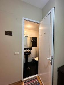 Un baño con una puerta de cristal que conduce a un inodoro. en Apartment Dadiani 26, en Tiflis 8 fotos más