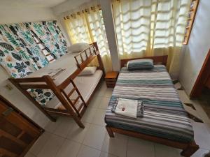 Puerto NariñoにあるHostal Beruのベッドルーム1室(二段ベッド2台、ソファ付)