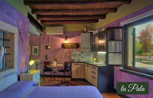 a kitchen with purple walls and a table with chairs at Il Borghetto Vacanze nei Mulini in Valeggio sul Mincio