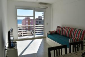 a living room with a couch and a large window at Baleine in Puerto Madryn