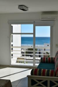 a living room with a large window with a view of the ocean at Baleine in Puerto Madryn