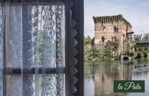 a window with a view of a castle in the water at Il Borghetto Vacanze nei Mulini in Valeggio sul Mincio