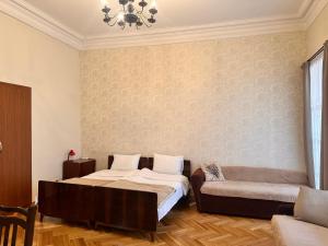 sypialnia z łóżkiem i kanapą w obiekcie Apartment Dadiani 26 w mieście Tbilisi City