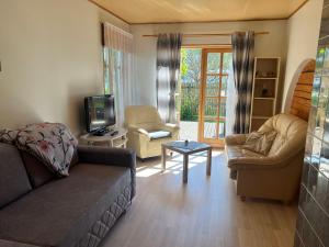 a living room with a couch and chairs and a tv at Papli Apartment near the Beach in Pärnu