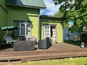 a wooden deck with a chair and an umbrella at Papli Apartment near the Beach in Pärnu