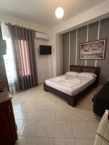 a bedroom with a bed and a couch and a television at Eid Mar in Vlorë