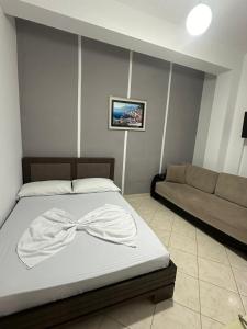 Un dormitorio con una cama con una pajarita. en Eid Mar en Vlorë