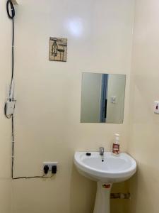 y baño con lavabo y espejo. en Trice Homes One Bedroom Condo at Lavender Apartment, en Nanyuki