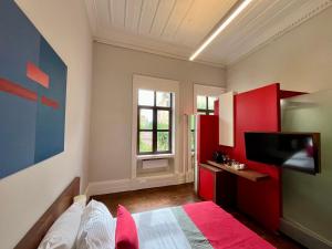 a bedroom with red cabinets and a tv on the wall at Thirty8 Heritage House in Chania Town