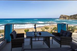 einen Balkon mit Tisch und Stühlen sowie Strand in der Unterkunft Stegna Sea & Sun in Archangelos
