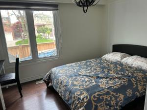 een slaapkamer met een bed en een groot raam bij KenHouse in Toronto