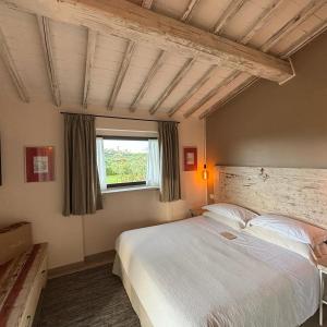 - une chambre avec un grand lit et une fenêtre dans l'établissement Podere Bellavista, à San Gimignano