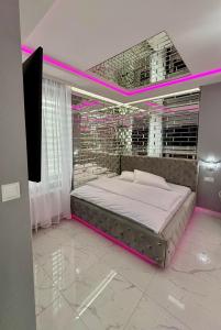 a bedroom with a bed with pink lighting at Apartament "Prezydencki Deluxe" Centrum z dużą wanną dla Dwojga in Gniezno