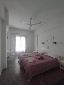 a bedroom with two beds and a window at Kalamionas Studios & Apartments in Kassiopi