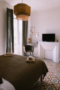 a bedroom with a bed with a chair and a television at L'Orangeraie d'Afa in Afa