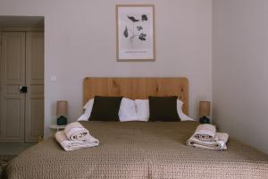 sypialnia z dużym łóżkiem z ręcznikami w obiekcie L'Orangeraie d'Afa w mieście Afa