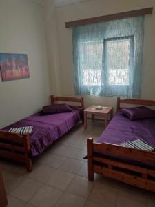 Zimmer mit 2 Betten und einem Fenster in der Unterkunft Beautiful apartment ANAIS near the sea in Agía Triás