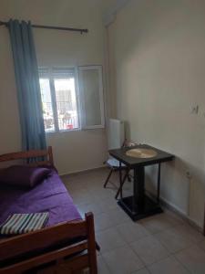 Habitación con cama, mesa y ventana en Beautiful apartment ANAIS near the sea en Agia Triada