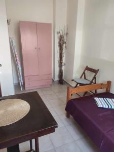 Habitación con cama, mesa y armario. en Beautiful apartment ANAIS near the sea en Agia Triada