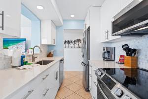 a kitchen with white cabinets and a sink at Our House at the Beach 604E By Beachside Management in Siesta Key