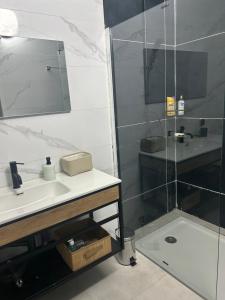 a bathroom with a sink and a shower at Charmante villa avec piscine, 3 chambres, salon, cuisine séparée! in Gandigal