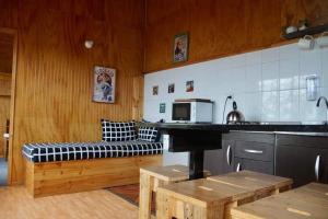a kitchen with a counter and a bench in a room at Aikus in Mantilhue