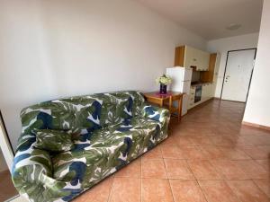 Il comprend un salon avec un canapé et une cuisine. dans l'établissement VRclub - Villa Ridente Residence, à Gioiosa Marea