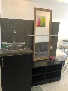 a bathroom with a sink and a mirror next to a bed at Aeropod 5 mins to Airport 10 mins to KK city in Kota Kinabalu