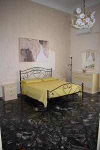 a bedroom with a bed with a yellow blanket at Palazzo San Francesco in Scorrano