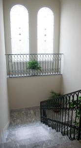 a stairway with two windows and a wrought iron railing at Palazzo San Francesco in Scorrano