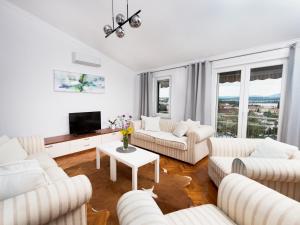 a living room with white couches and a tv at Apartment Olive Malinska - Panoramic Sea View in Malinska +29 photos