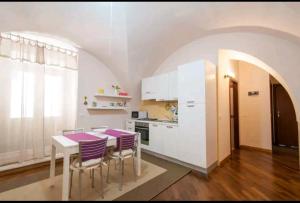 une cuisine avec une table et des chaises violettes dans l'établissement Madre Terra, à Toritto