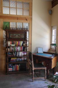 Zimmer mit einem Schreibtisch und einem Bücherregal mit Büchern in der Unterkunft Presshaus Alte Mühle in Stainz