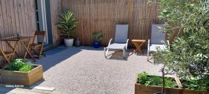 un patio con sillas, mesa y plantas en "Chez Lyly et Juju" Piscine&Calme 3Chambres, en Angers