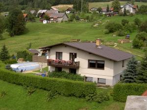 una casa blanca en un campo verde con una casa en Guest House Bulušek, en Rokytnice nad Jizerou