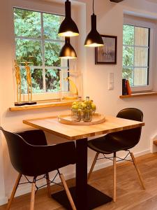 a dining room with a wooden table and chairs at Sommerhaus Reethaus "M" in Grödersby