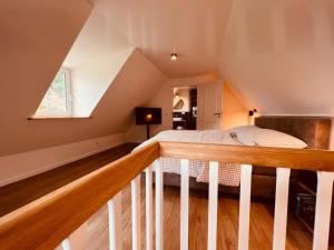 a attic bedroom with a bed and a staircase at Sommerhaus Reethaus "M" in Grödersby