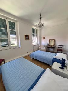 a bedroom with two beds and a chandelier at San Romano centro storico in Lucca