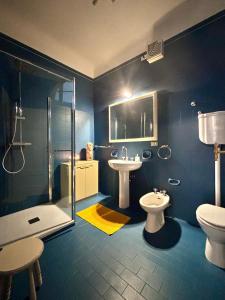 a blue bathroom with a toilet and a sink at San Romano centro storico in Lucca +24 photos