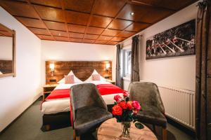 een hotelkamer met een bed en twee stoelen bij Hotel Tradizio in Mittelberg