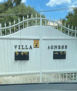 un bâtiment blanc avec un panneau indiquant l'excédent de la villa dans l'établissement Villa Agnese, à Badesi