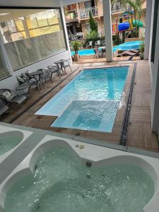 uma piscina com uma banheira de hidromassagem num edifício em Pousada Duas Ilhas em Penha