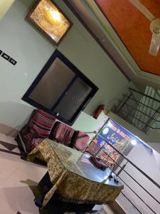 Safari Hotel في Dera Ghāzi Khān: غرفة معيشة مع تلفزيون وطاولة مع كرسي