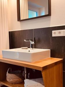 ein Badezimmer mit einem weißen Waschbecken und einem Spiegel in der Unterkunft Sommerhaus 54, Gartenhaus "S" in Grödersby