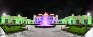 un edificio con una fontana di fronte ad esso di notte di HOTEL SULTAN PALACE a Samarkand