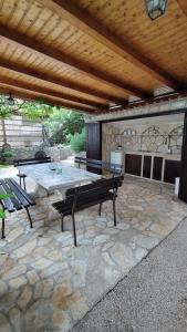 a patio with a bench on a stone patio at Kuća za odmor Giulitta in Porat